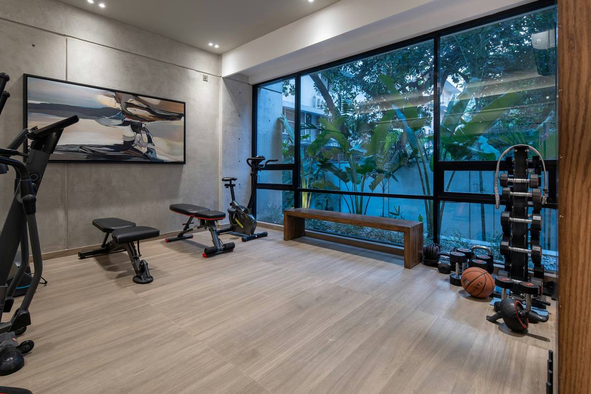 Modern track lighting home gym setup with adjustable heads illuminating a weightlifting area