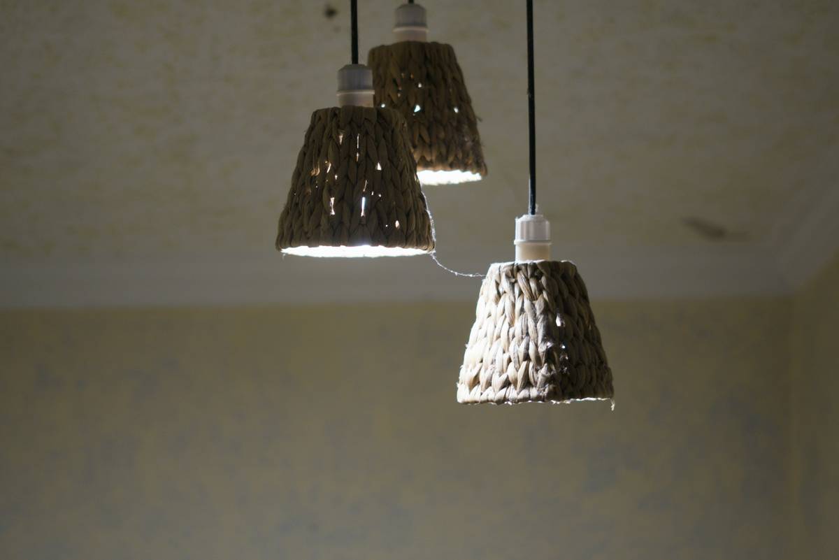 Modern new track lighting fixtures mounted above a kitchen island with adjustable heads aimed at countertops and artwork