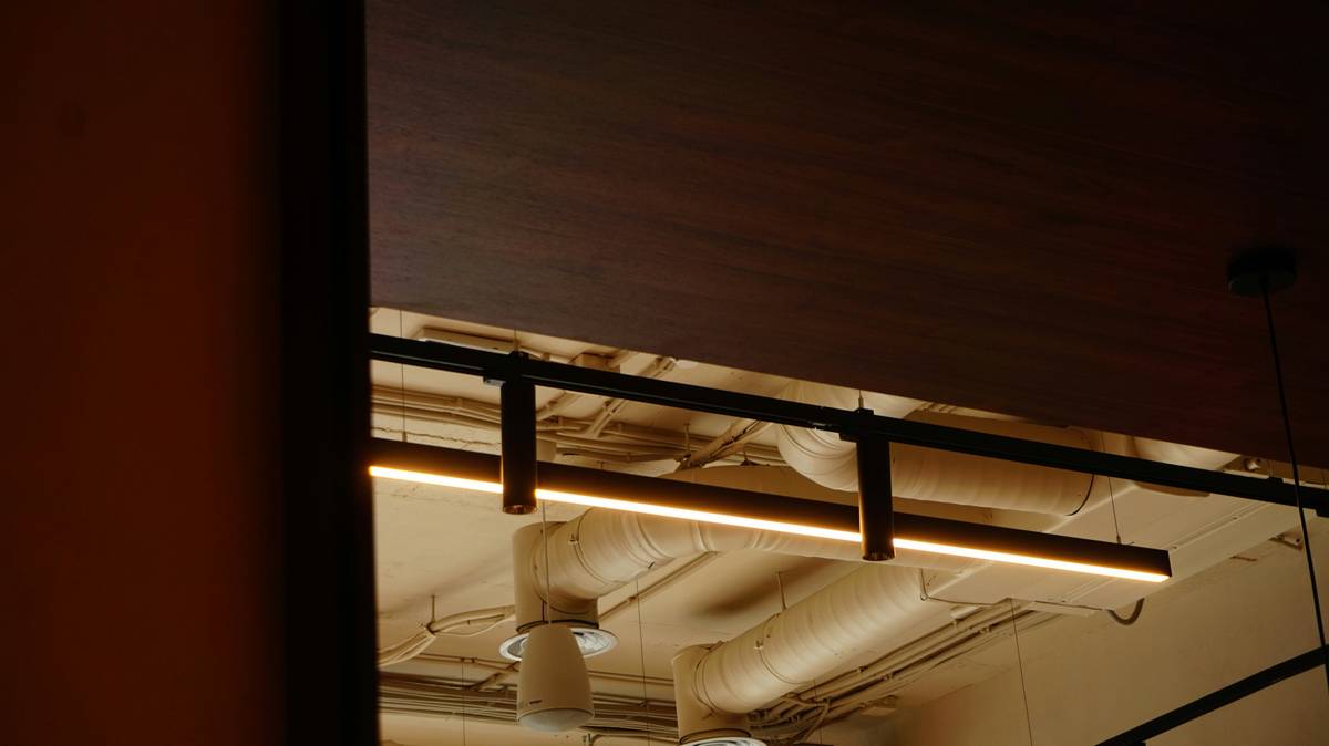 Modern kitchen with track LED lighting fixtures highlighting countertops and artwork